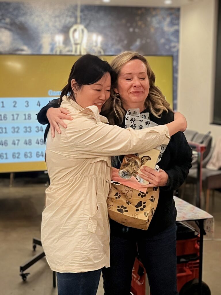 Two Bingo Night guests sharing a hug at the fundraiser