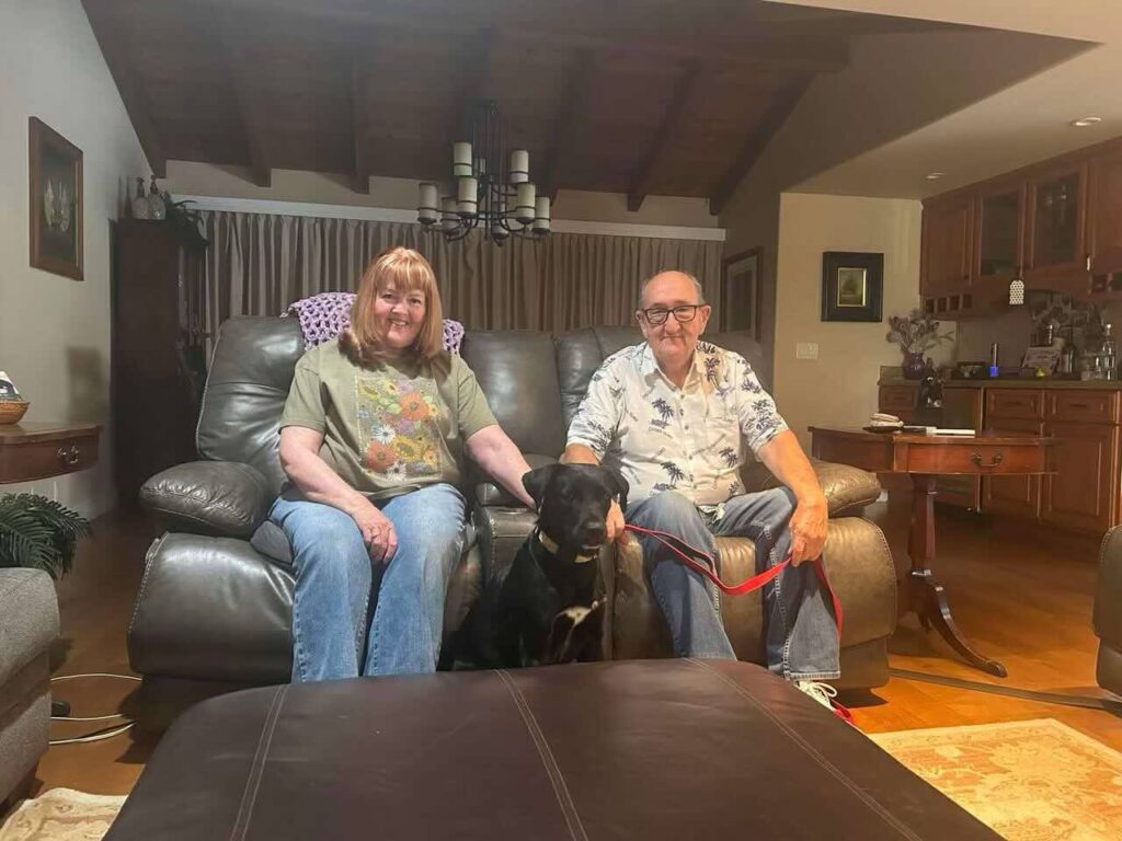 Tara sitting with her adopters in her new home.