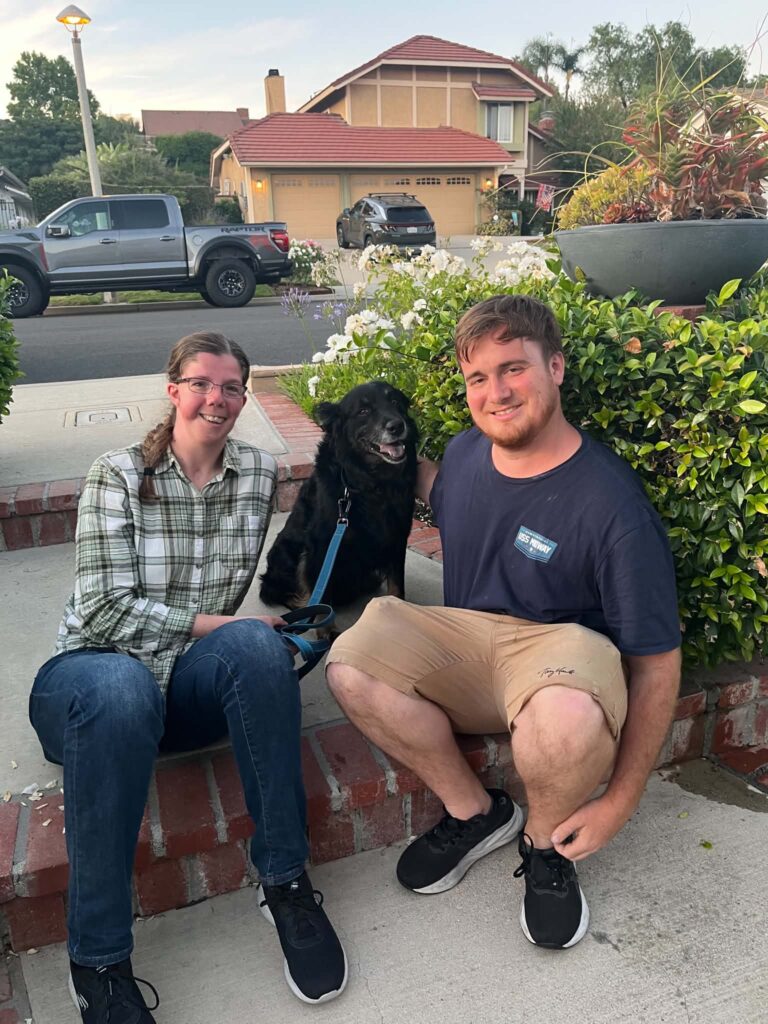 Habanero sitting outside with his smiling adoptive couple, celebrating the beginning of his new life.