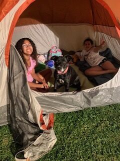 Apple snuggled inside a tent with the Toliver daughters during one of their many family adventures together.